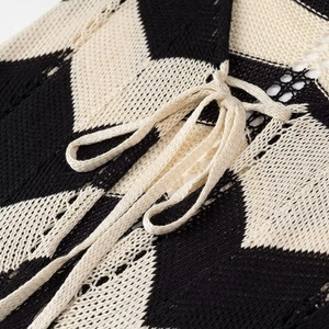 Detail des Chevron-Strickkleids mit beigefarbenem Kordelzug und strukturierter Webart