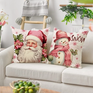 Detail view of pink Christmas pillow covers featuring Santa and Snowman on a sofa