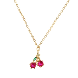 Macro view of cherry fruit pendant with red and green zircons on gold chain