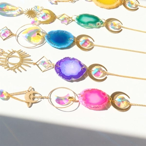 Detailed flat lay of crystal suncatchers with natural agate slices and sun moon prisms