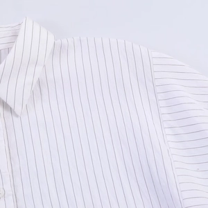 Detail view of the classic lapel and shoulder seams on this white striped cotton blouse