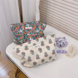 Close-up of floral cotton makeup bags with simple wish label on rustic desktop