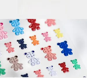 Macro shot of 5D teddy bear nail art stickers with fine stitched leather texture