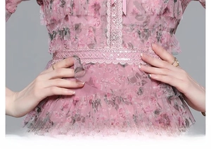 Détail de robe fleurie rose avec bordure en dentelle à la taille et volants étagés