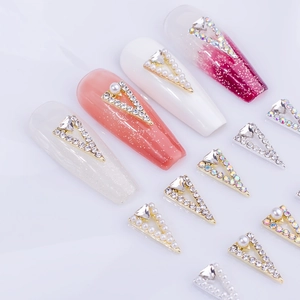 Eleganti ciondoli per unghie a forma di V con perle e strass su sfondo bianco puro
