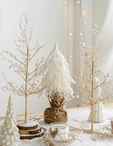 Detail van een verlichte gouden kerstboom van metaaldraad met kristallen op houten voet