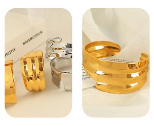Detailed view of gold and silver C-shaped cuff bracelets with a rippled metallic texture