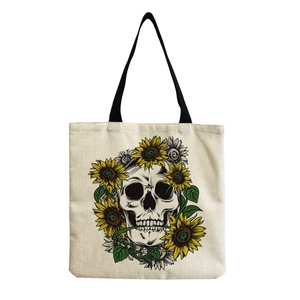 Detail of sunflower and skull print on canvas tote bag with black shoulder strap
