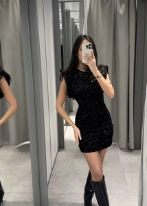 Gros plan d'une mini robe noire à paillettes avec épaulettes en vue miroir selfie
