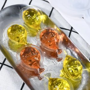 Vista dettagliata di stampi in silicone a forma di pesce giallo e arancione su vassoio
