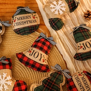 Détail de suspensions de Noël en toile de jute à carreaux avec cloches et nœuds déco