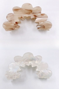 Close-up of wavy acrylic hair claws in tortoiseshell and pearlescent white finish