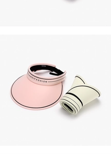 Detail view of foldable sun visor hats in pink and beige with portable roll-up design