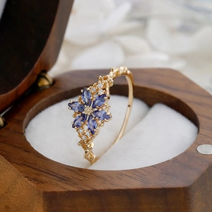 Macro shot of vintage floral ring with blue marquise stones in wooden gift box