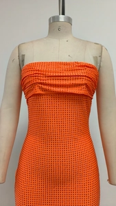 Détail de la robe bustier orange ornée de strass brillants et coupe moulante