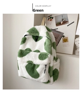 Detail shot of green and white heart-pattern plush backpack with soft faux fur texture