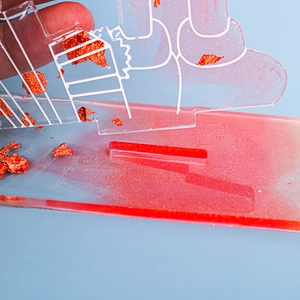 Removing the protective film from a clear acrylic display stand with red gradient base