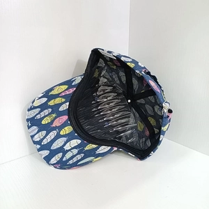 Detailed side view of navy blue baseball cap with colorful feather prints and interior support
