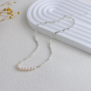 Macro shot of silver irregular geometric chain necklace with seven natural pearls
