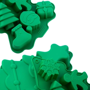 Close-up of two green silicone Christmas molds featuring gingerbread man and tree patterns