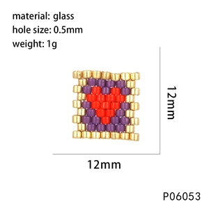 Détail macro d'une perle en verre en forme de cœur de 12 mm en or, violet et rouge