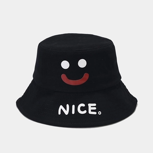 Close-up of a black cotton bucket hat featuring a red smiley face and NICE lettering