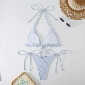 Detail of light blue textured bikini set with silver beads and summer beach accessories