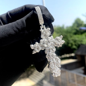 Vue macro d'un pendentif croix argenté glacé serti de zircons brillants à la main