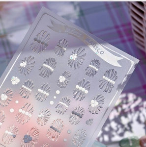 Macro shot of 3D embossed shell texture nail stickers with pearl accents on lilac background