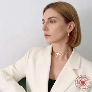 Close-up of gold drip choker and hoop earrings on model for a modern fashion look