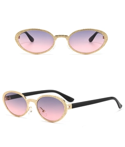 Detailed macro view of vintage gold metal oval frames with purple gradient lenses