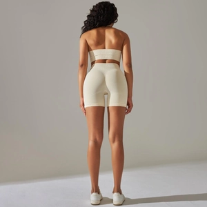 Detail of seamless ribbed knit texture on high waist cream yoga shorts and sports bra set