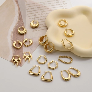 Various styles of 18k gold geometric hoop earrings including heart and twisted designs