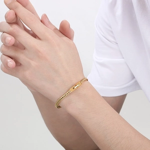 Nahaufnahme eines goldenen Edelstahl-Gliederkettenarmbands mit quadratischem Verschluss