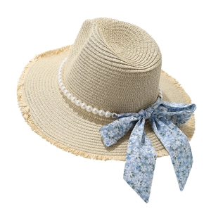 Beige raffia sun hat with floral bow, pearl trim, and fringe brim for beach vacations