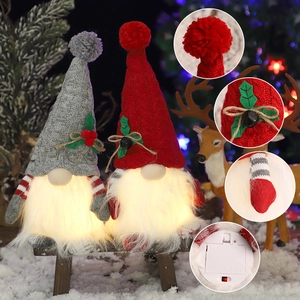 Gnomi di Natale luminosi con cappelli di maglia e bacche di agrifoglio per la festa