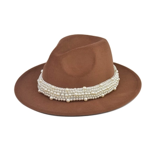 Detalle de sombrero fedora marrón con cinco filas de elegantes perlas blancas