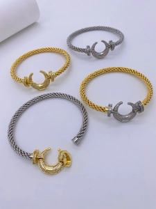 Detailed macro shot of 18K gold horseshoe braided bracelets with zircon inlay details