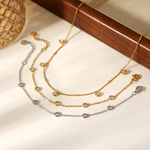 Detail of three layered gold and silver anklets with sparkling round zircon stones