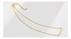 Detailed close-up of golden bar pendant necklace with lobster clasp and extension chain