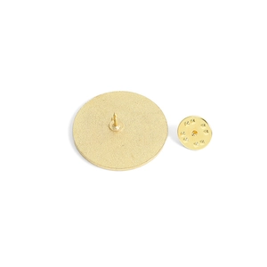 Golden round metal badge with butterfly pin clasp and textured matte back finish