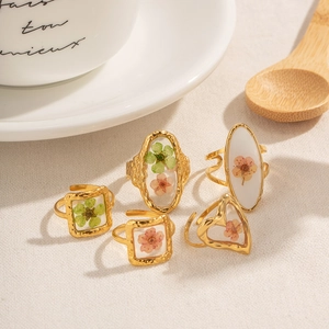 Golden stainless steel rings with colorful dried flowers in epoxy, chic ocean series style