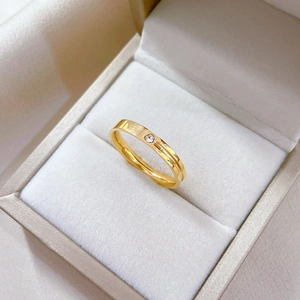 Gold plated titanium steel ring with central groove and small white zircon inlay
