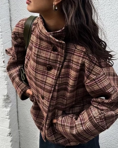 Detail of vintage plaid tweed jacket with high neck and retro buttons in brown earth tones