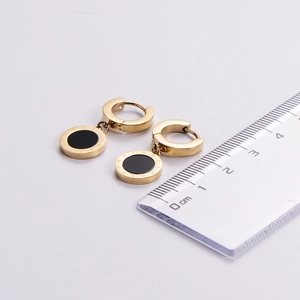 Detailed view of 18k gold plated roman numeral earrings with ruler for size reference