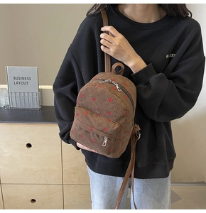Detail of vintage brown corduroy backpack with red strawberry print and metal zipper