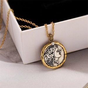 Detailed macro view of vintage Roman coin pendant with Athena relief and pearl accent