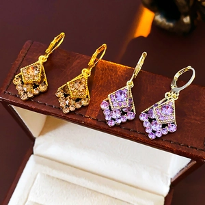 Detailed view of diamond-set leaf earrings in champagne and purple crystals