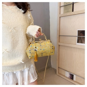 Elegant yellow embroidered evening bag featuring golden chain strap and silk tassel detail