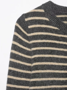 Detailed close-up of dark grey striped knitted sweater showing soft wool texture